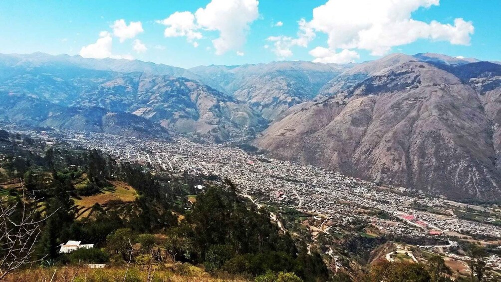 Un paisaje montañoso con un pueblo asentado en el valle. 3