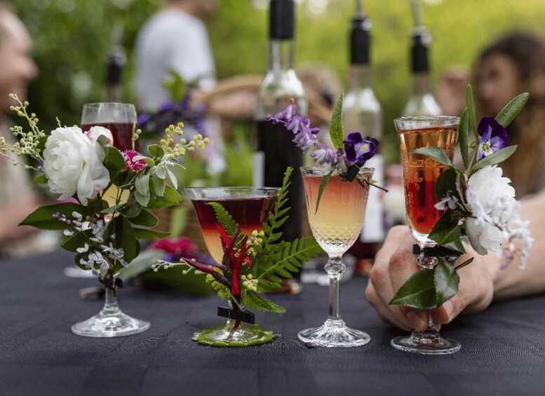 Three glasses of drinks with flowers on a table. 1