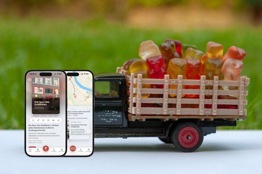 A toy truck filled with gummy bears, a smartphone displaying a map, and a blurred green background. 1