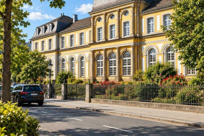 A yellow building with arched windows and a fence with flowers. 5