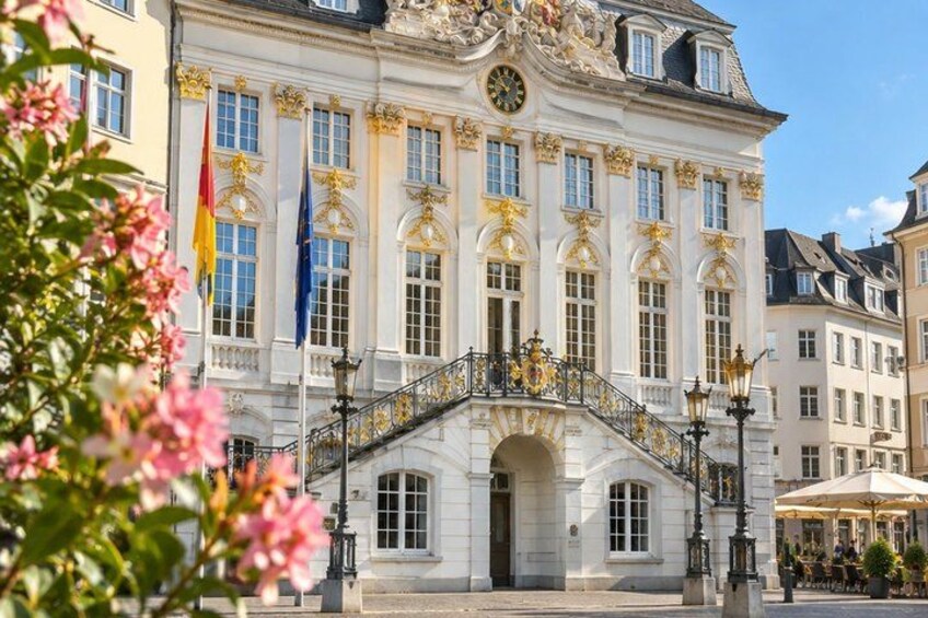 A historic building with ornate architecture, a grand staircase, and flags. 3
