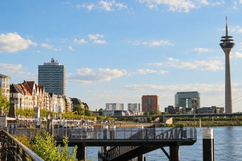 A city skyline with a prominent tower, a river, and a bridge. 5
