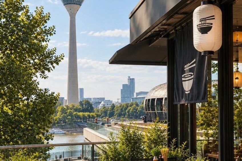 A restaurant with a view of a river, a tower, and a cityscape. 2