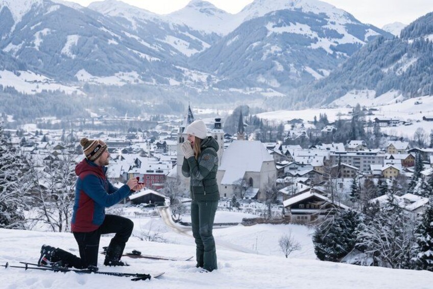 A snowy mountain landscape with a small village, a church, and a person proposing to another. 3