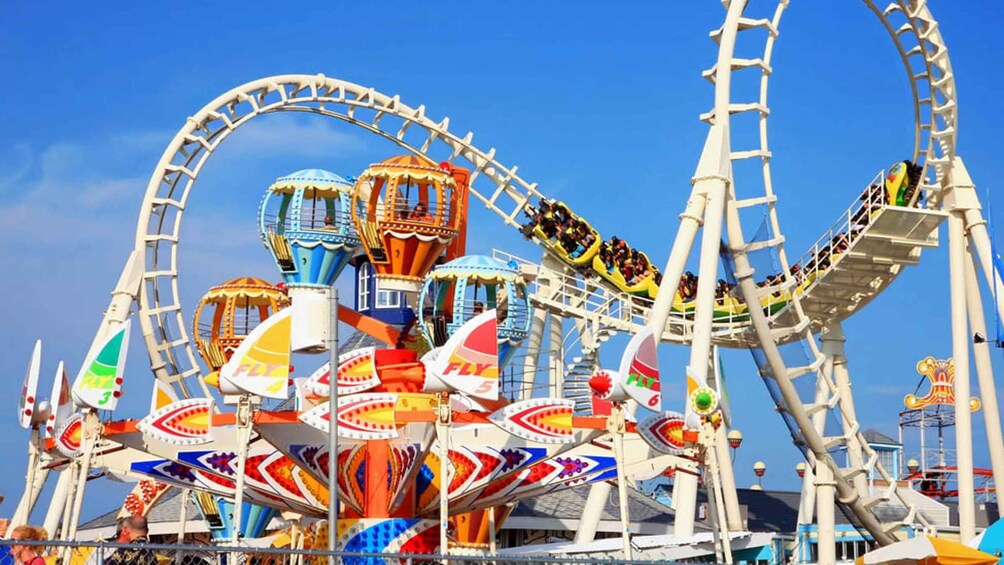 Una atracción de parque de diversiones colorida, con una noria grande y otras atracciones más pequeñas. 1