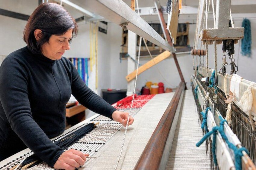 A person weaving on a loom. 1