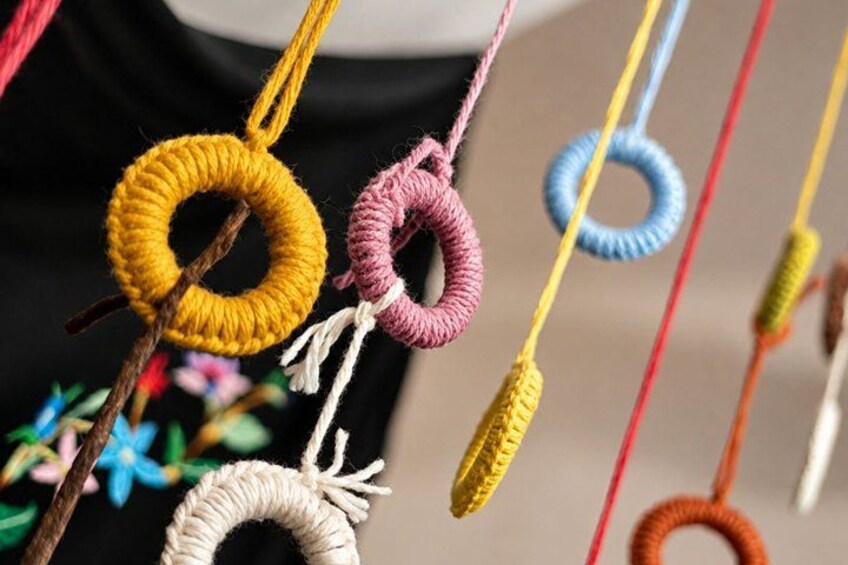 Colorful yarn loops on sticks, possibly part of a craft or decoration. 4