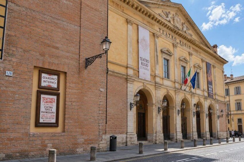 A historic building with arched doorways and banners, including one for a restaurant. 5