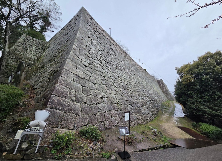 Una estructura piramidal de piedra con una silla metálica y señalización informativa. 2