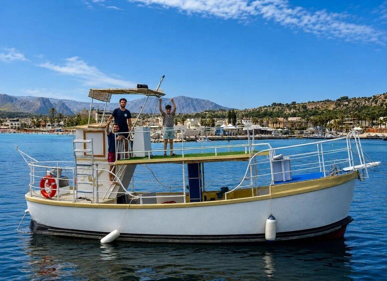 Un pequeño barco amarrado en un puerto deportivo con montañas al fondo. 2