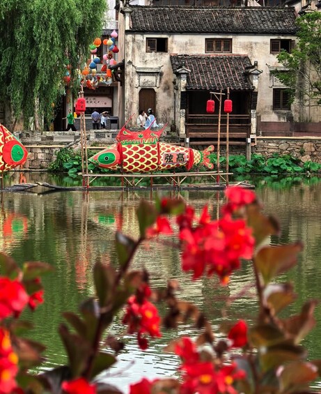 Un bâtiment traditionnel chinois, doté d’un toit recouvert de tuiles, d’une décoration représentant des poissons flottants et d’un bassin orné de feuilles de lotus. 2