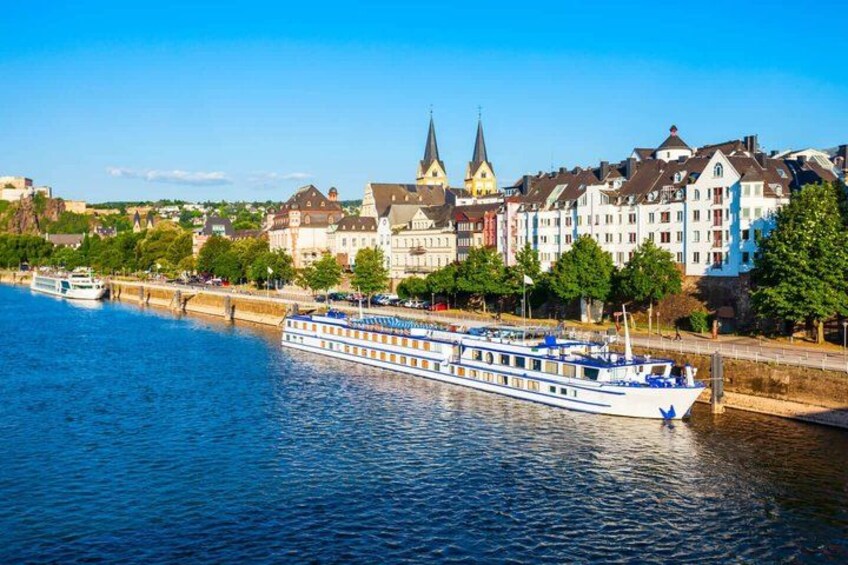 A river with a boat, buildings, and a bridge. 1