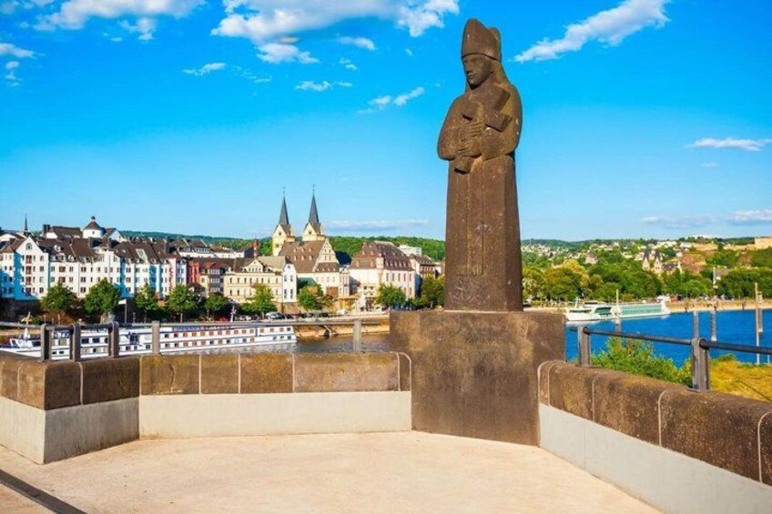A statue on a bridge, a river, and a town with historic buildings. 2