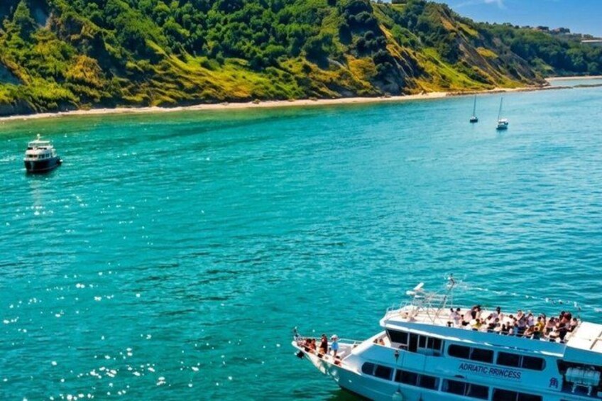 A boat named 'Adriatic Princess' on turquoise waters with a forested coastline in the background. 5