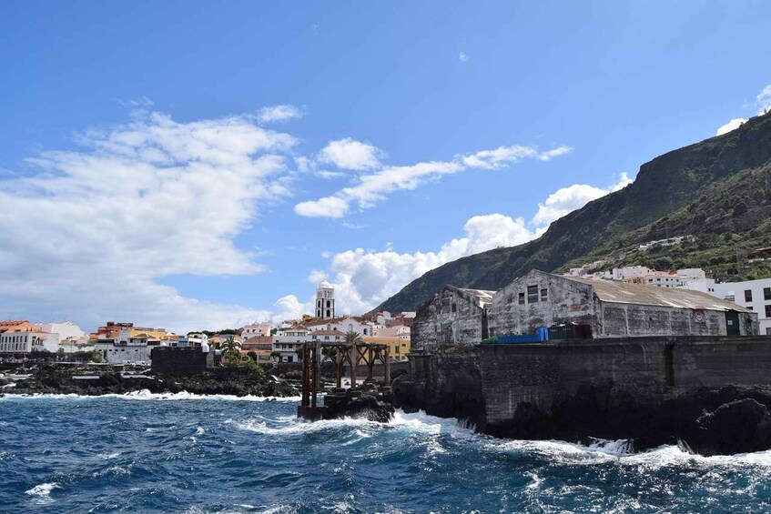 A coastal town with buildings, a church, and a rocky shoreline. 5