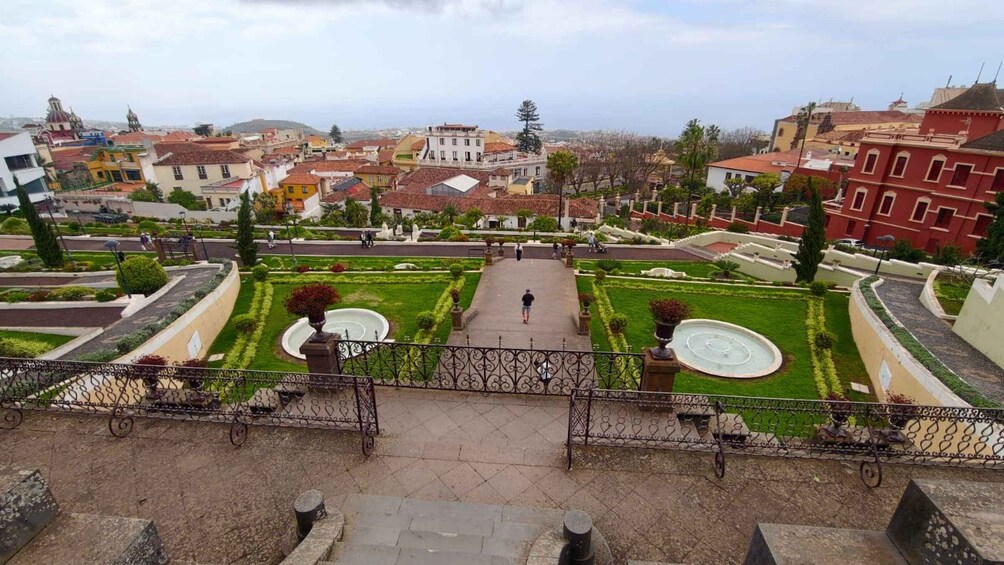 A cityscape with a central garden featuring fountains, surrounded by residential buildings. 3