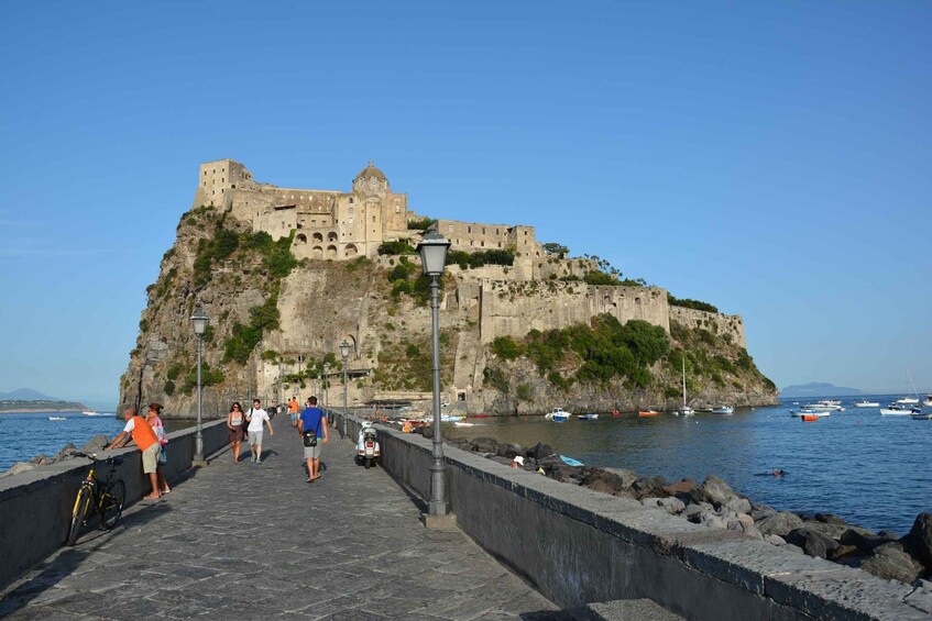 A stone pathway leading to a historic fortress on a cliff overlooking the sea. 1