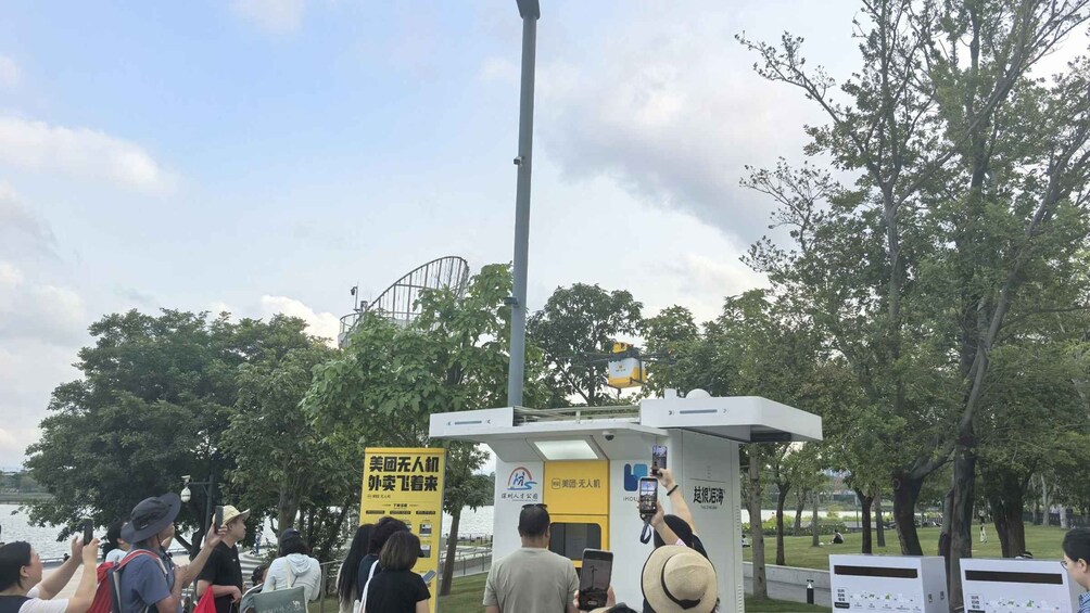 Un parque con gente, un cartel amarillo y una estructura alta. 4