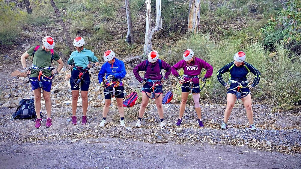 A group of people preparing for a bungee jump in a forested area. 3