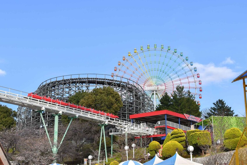 Des montagnes russes, une grande roue et un bâtiment rouge avec une enseigne. 2