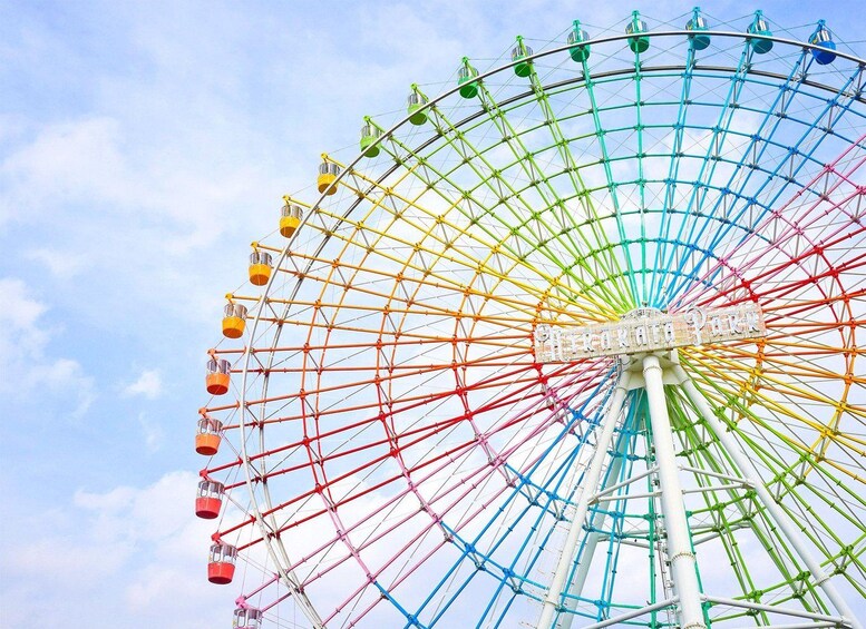 Une grande roue aux couleurs vives, avec ses nacelles, se dressant devant un ciel dégagé. 3