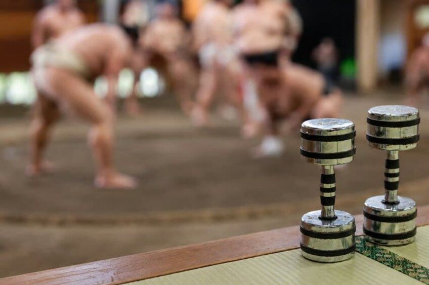 A sumo wrestling match with wrestlers in traditional attire. 2