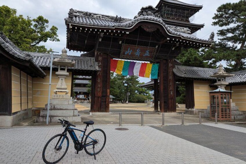 A traditional Japanese gate with a bicycle parked in front. 5
