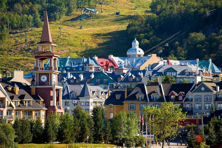 Eine Stadt mit bunten Häusern, einem Kirchturm und einem Hügel mit einer Seilbahn. 1