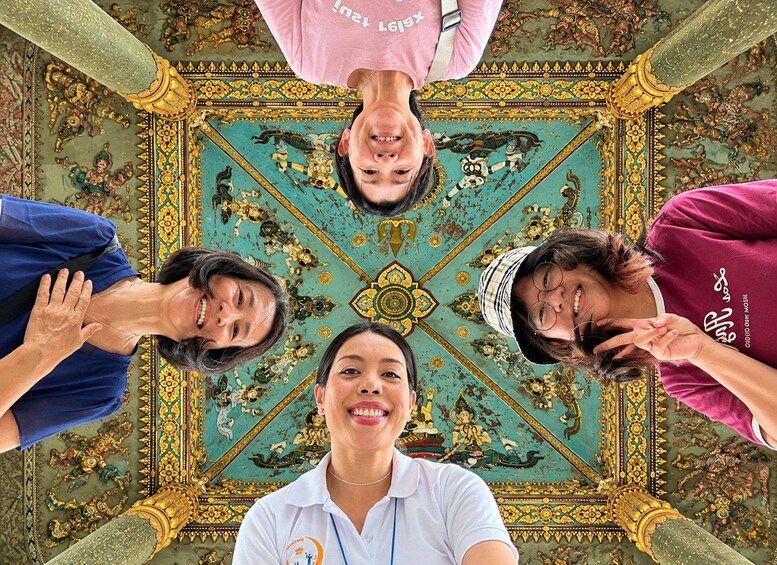Un grupo de personas en una habitación con elaborados y coloridos adornos en el techo. 1