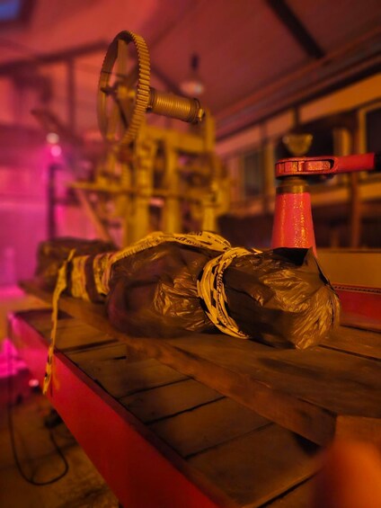 A plastic bottle with a red cap, tied with a rope, on a wooden surface. 5