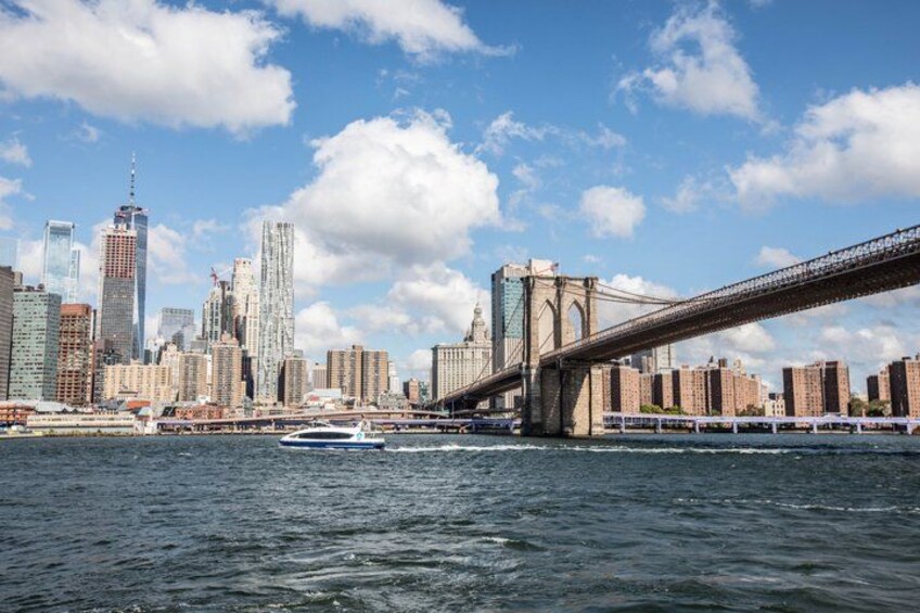 A river with a bridge, a city skyline, and a boat. 2