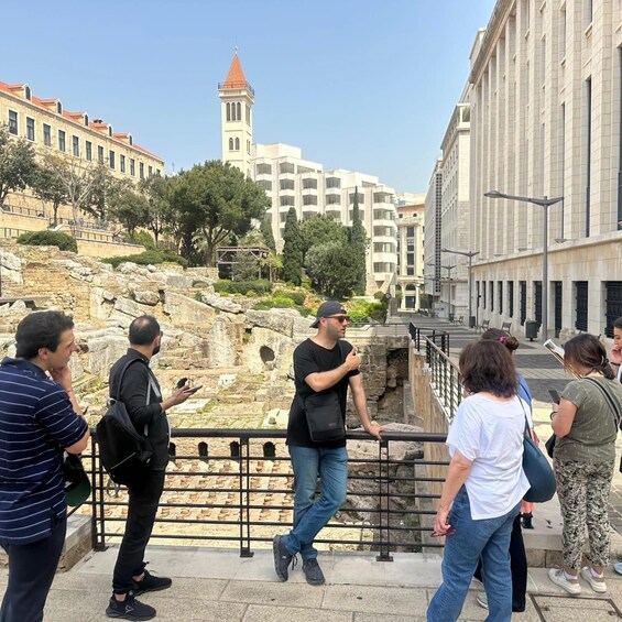 Tourists observing ancient ruins and a church tower. 2
