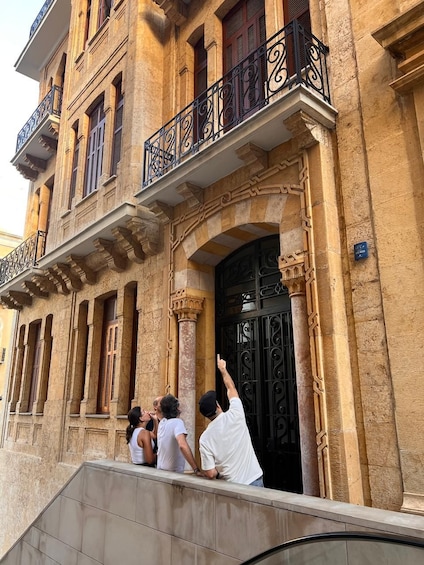 A historic building with ornate balconies and a black wrought iron gate. 1