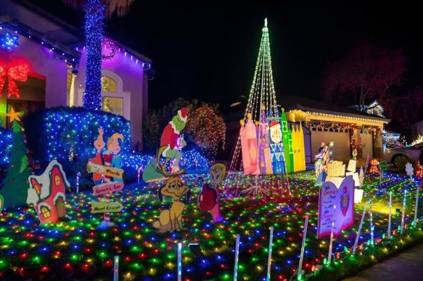 A house decorated with colorful lights, a Christmas tree, and various holiday-themed figures. 4