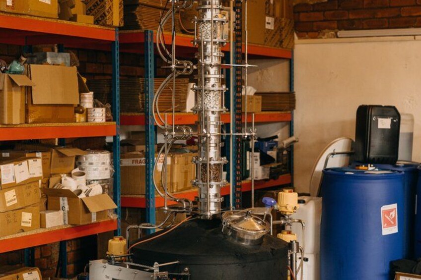 A laboratory with shelves stocked with boxes, a large piece of equipment, and a blue barrel. 5