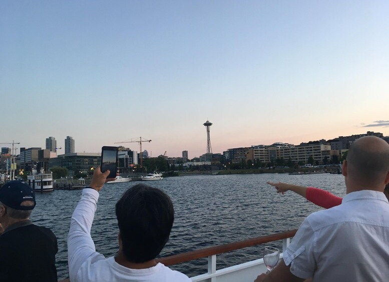 A city skyline with a prominent tower, a body of water, and a person taking a photo. 5