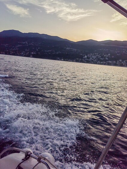 A boat on a lake with waves, mountains in the background, and a clear sky. 3