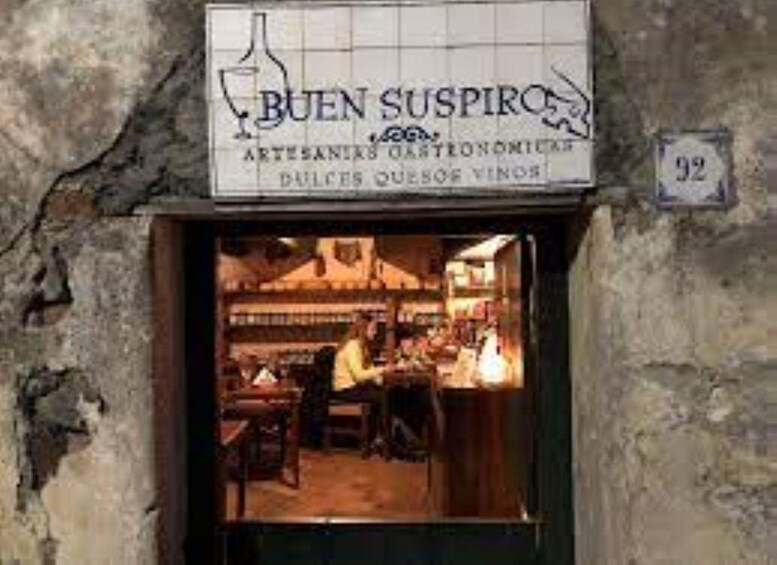A storefront with a sign reading 'BUEN SUSPIRO' and a number '92' on the wall. 5