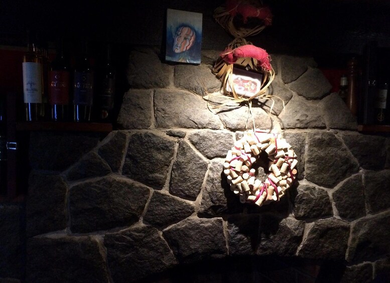 A stone fireplace with a wreath made of wine corks. 2