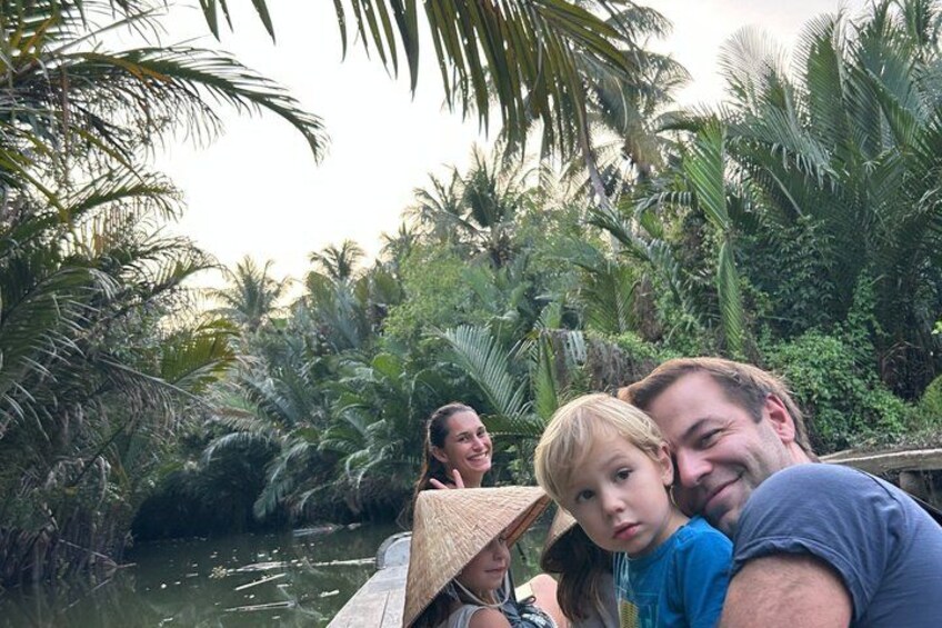 A group of people on a boat surrounded by dense tropical vegetation and palm trees. 4