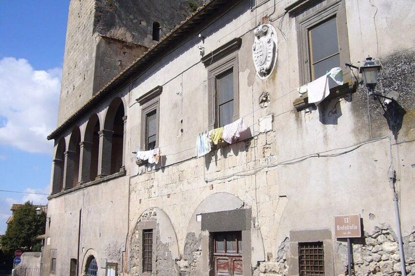 A historic building with arched windows and a sign reading 'Casa del Mutilato.' 5