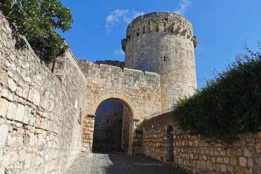 A stone castle with a round tower and an arched entrance. 3
