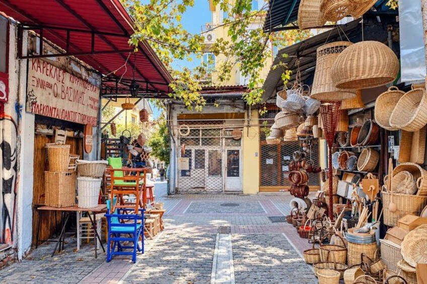 A street with various baskets and wicker items displayed outside shops. 2