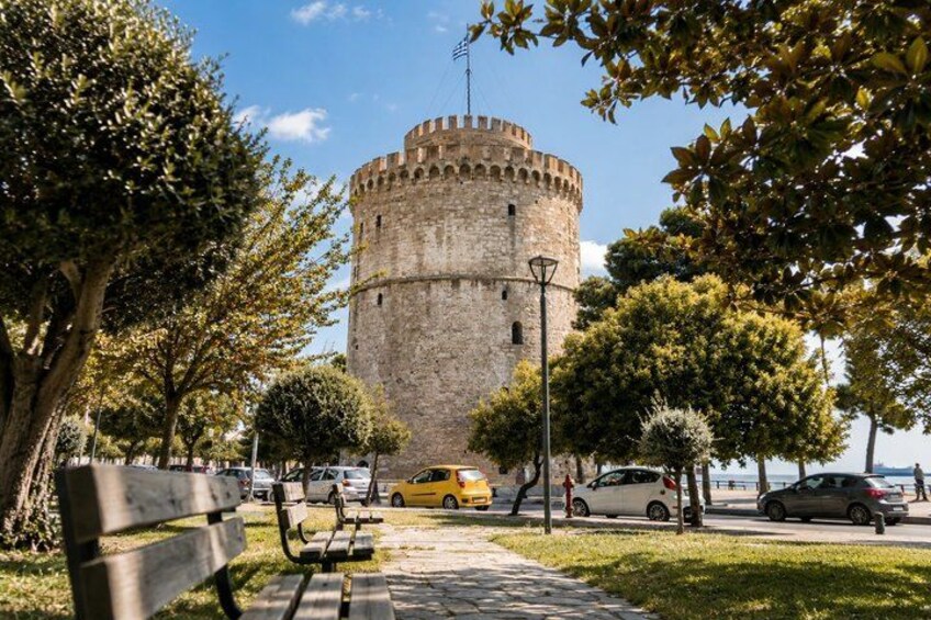 A historic stone tower, a paved walkway, and a yellow car. 3