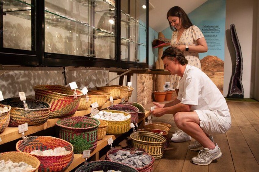 A person examining baskets on a wooden shelf in a store. 2