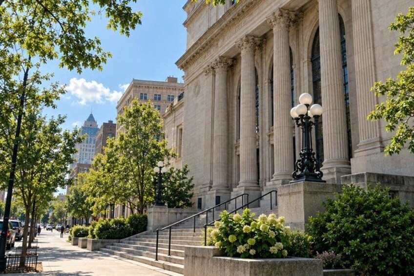 A grand building with large columns, a staircase, and a lamppost. 3