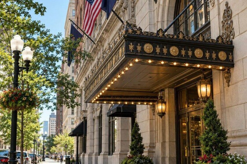A grand building with an ornate marquee, American flags, and a well-lit entrance. 5