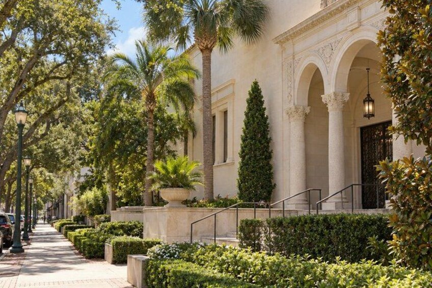 A building with columns, a staircase, and well-maintained greenery. 5