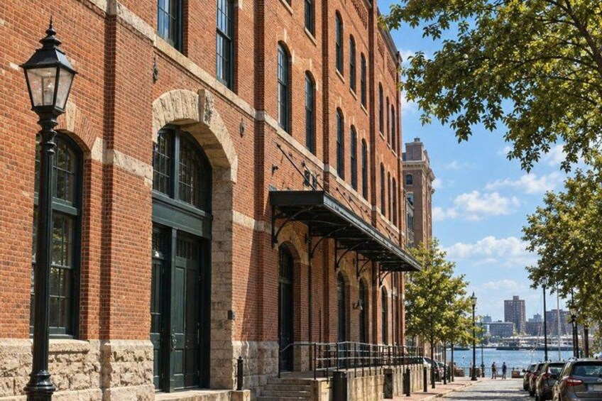 A brick building with arched windows and a black awning. 1