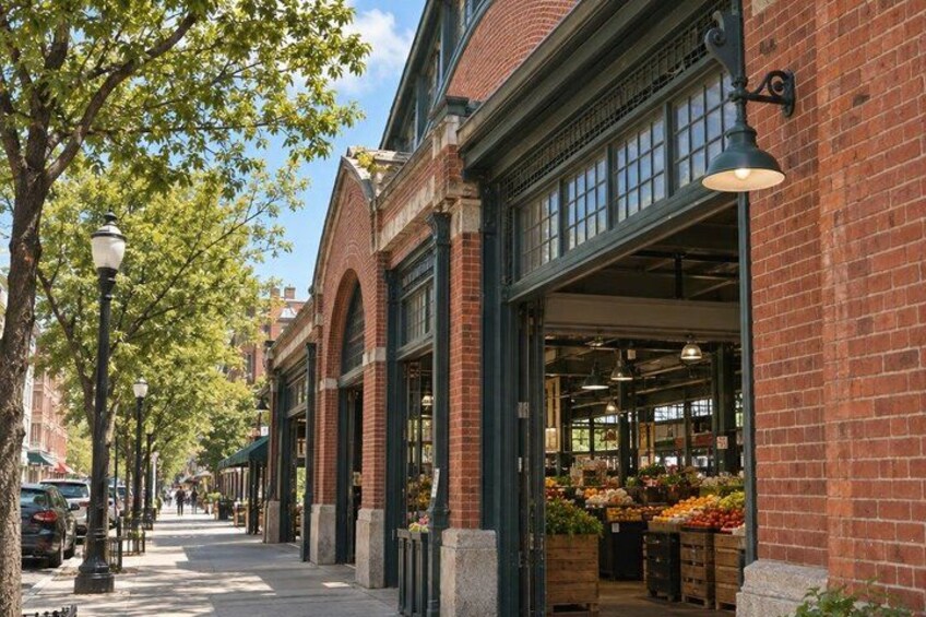 A brick building with large windows and a green awning, a street with trees and parked cars, and a street lamp. 4